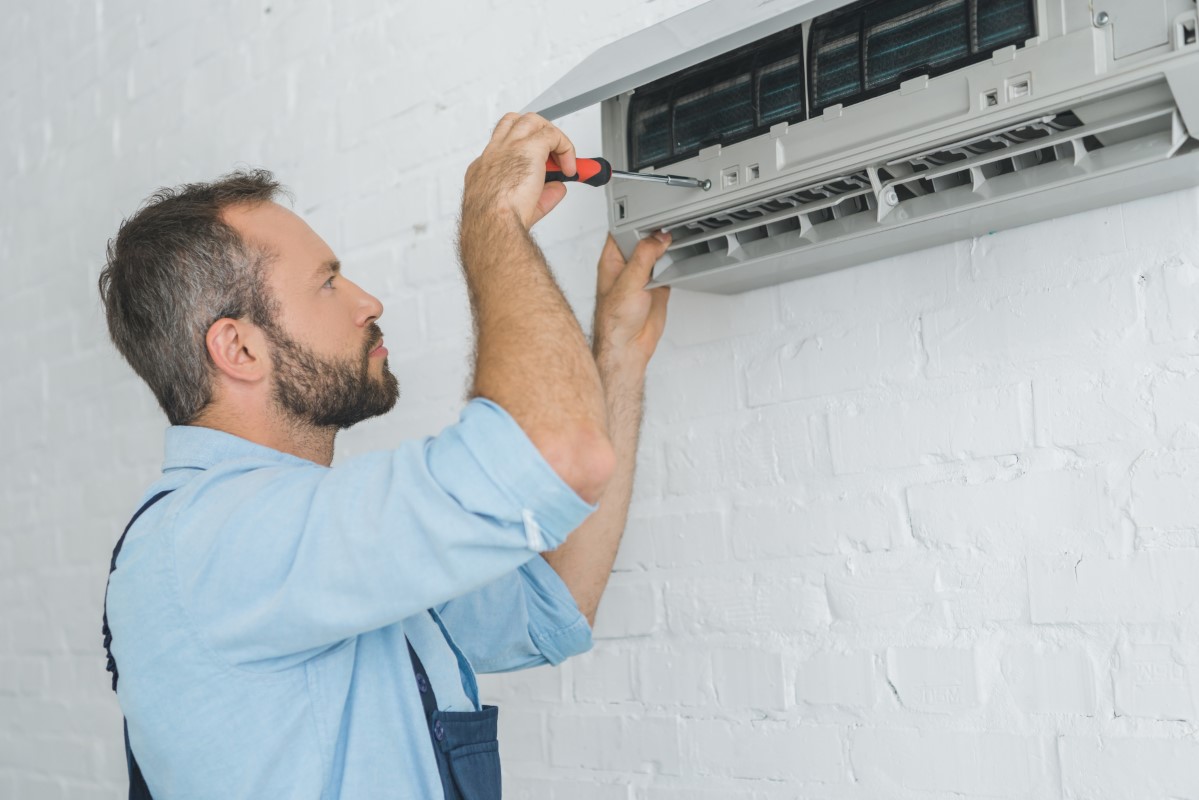 Profesional reparando aire acondicionado de pared